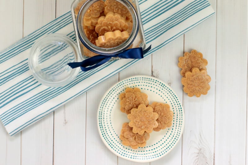 a glass container full of peanut butter dog treats and a plate