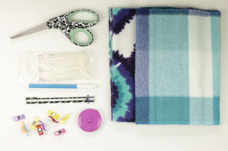 fleece, scissors, and sewing supplies on a white background
