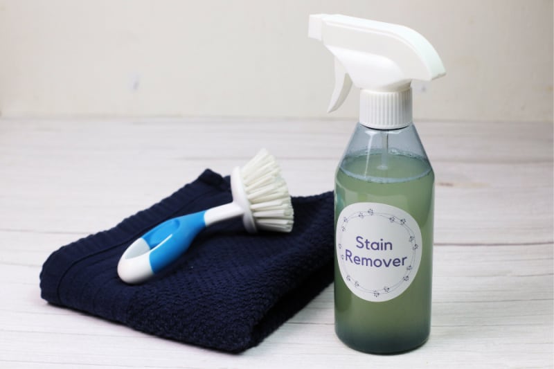 a spray bottle of cleaner with a scrub brush