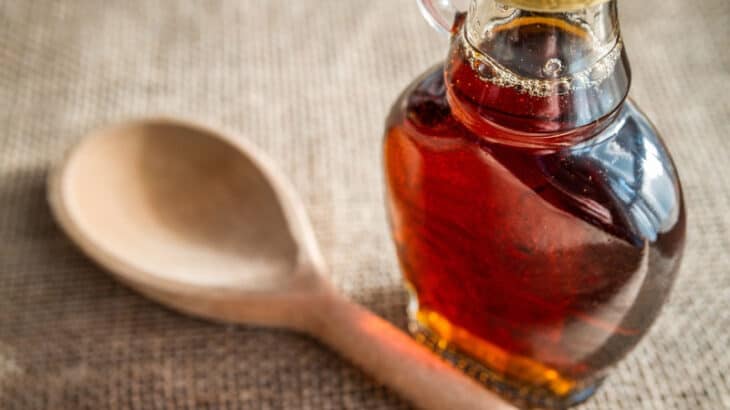 a jar of maple syrup and a wooden spoon